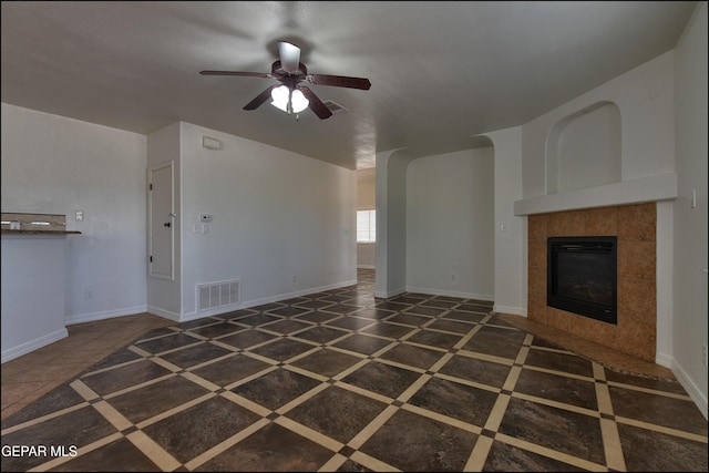 1493 Luz De Sol Dr, El Paso, TX 79912 - unfurnished living room featuring a ceiling fan, a tile fireplace, inlaid floor details, and baseboards