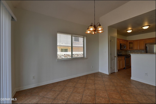 1493 Luz De Sol Dr, El Paso, TX 79912 - kitchen featuring appliances with stainless steel finishes, light tile patterned flooring, a chandelier, glass insert cabinets, and brown cabinetry