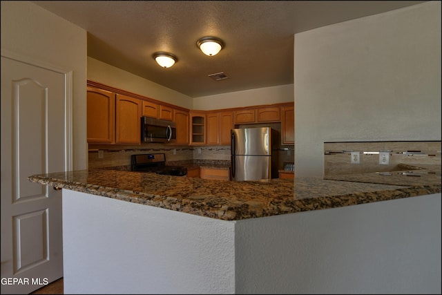 1493 Luz De Sol Dr, El Paso, TX 79912 - kitchen featuring stainless steel appliances, a peninsula, glass insert cabinets, and dark stone countertops