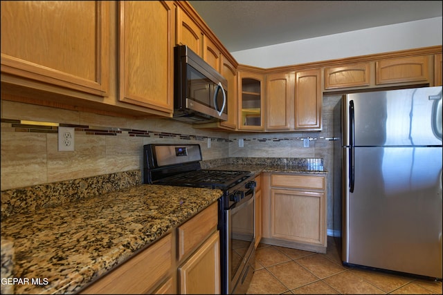 1493 Luz De Sol Dr, El Paso, TX 79912 - kitchen featuring stainless steel appliances, light tile patterned floors, backsplash, dark stone counters, and glass insert cabinets