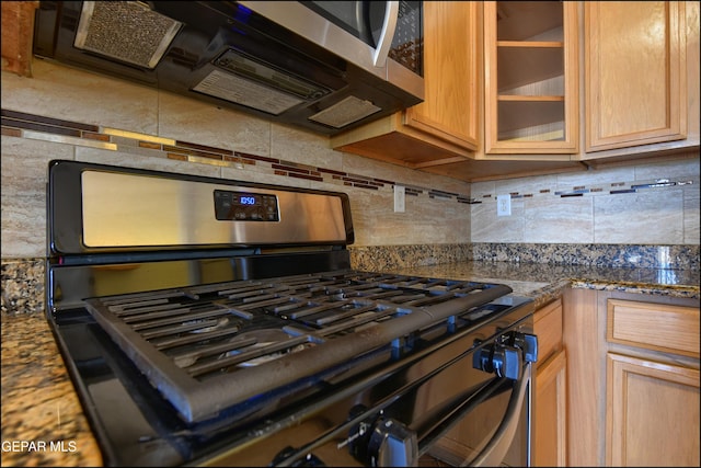 1493 Luz De Sol Dr, El Paso, TX 79912 - kitchen featuring appliances with stainless steel finishes, tasteful backsplash, glass insert cabinets, and dark stone counters