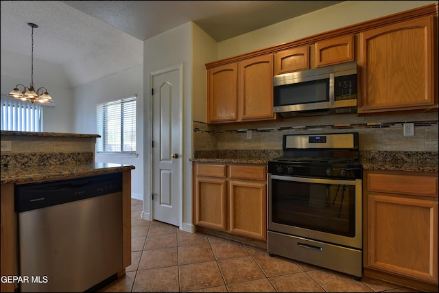 1493 Luz De Sol Dr, El Paso, TX 79912 - kitchen with stainless steel appliances, backsplash, vaulted ceiling, light tile patterned floors, and a chandelier