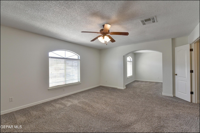 1493 Luz De Sol Dr, El Paso, TX 79912 - carpeted empty room with arched walkways, a ceiling fan, baseboards, and a textured ceiling