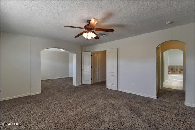 1493 Luz De Sol Dr, El Paso, TX 79912 - unfurnished bedroom featuring carpet floors, arched walkways, baseboards, and a textured ceiling