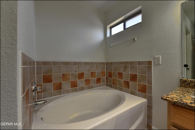 1493 Luz De Sol Dr, El Paso, TX 79912 - full bathroom with vanity, a garden tub, and a textured wall