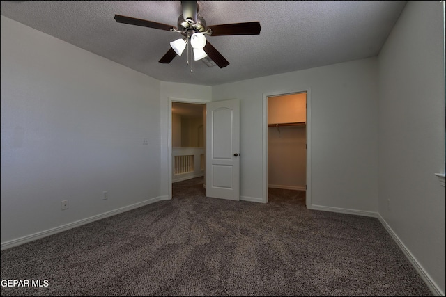 1493 Luz De Sol Dr, El Paso, TX 79912 - unfurnished bedroom featuring carpet floors, a textured ceiling, a spacious closet, baseboards, and a ceiling fan