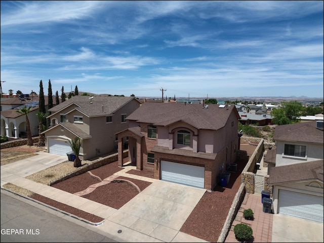 1493 Luz De Sol Dr, El Paso, TX 79912 - traditional home featuring driveway, a residential view, stucco siding, an attached garage, and a shingled roof