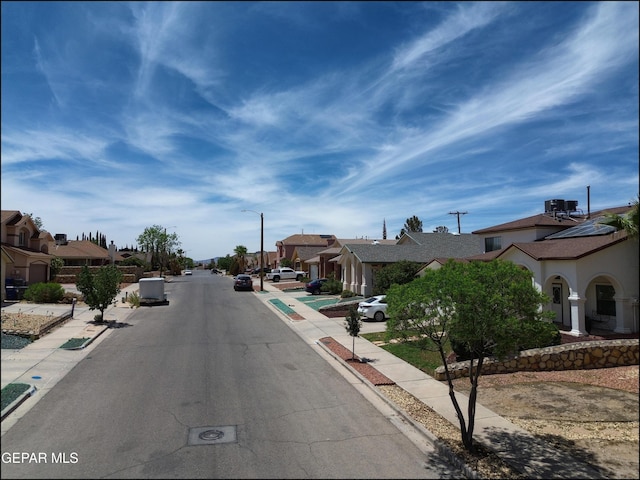 1493 Luz De Sol Dr, El Paso, TX 79912 - view of asphalt road featuring a residential view, sidewalks, curbs, and street lighting