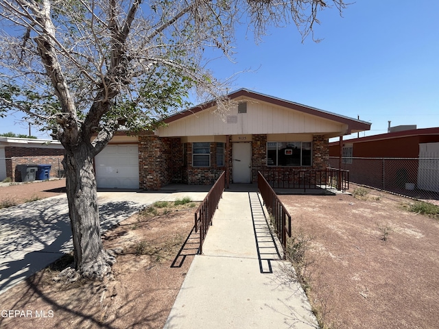 9125 Elgin Dr, El Paso, TX 79907 - view of front of house with an attached garage, driveway, covered porch, brick siding, and fence