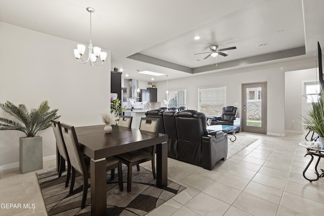 12405 Northumberg Dr, El Paso, TX 79928 - dining area featuring a raised ceiling, ceiling fan, light tile patterned floors, a chandelier, and baseboards