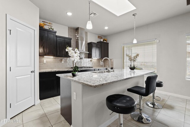 12405 Northumberg Dr, El Paso, TX 79928 - kitchen with a sink, a skylight, wall chimney range hood, backsplash, and plenty of natural light