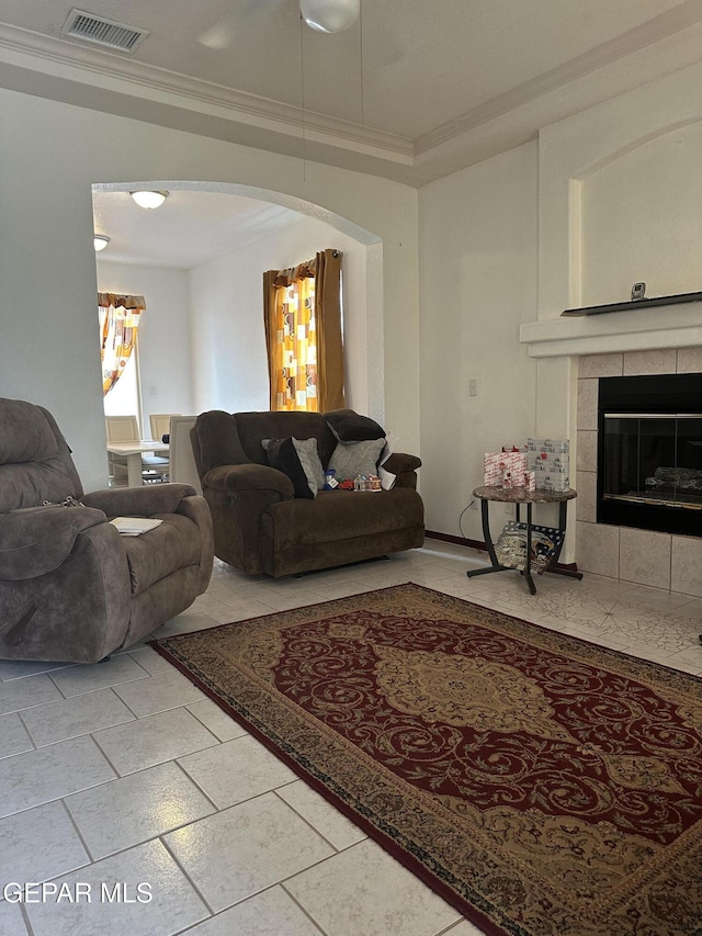 14045 Lago Seco Dr, Horizon City, TX 79928 - living area featuring crown molding, arched walkways, a fireplace, and light tile patterned floors