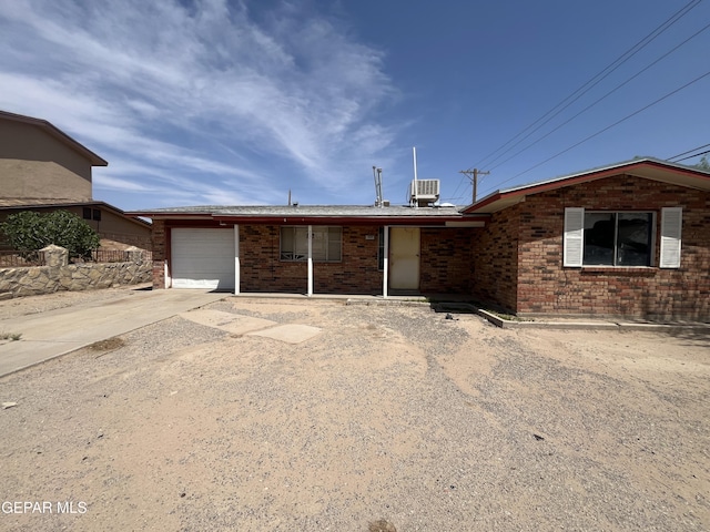 220 Maravilla Dr, El Paso, TX 79907 - ranch-style home featuring concrete driveway, brick siding, a garage, and cooling unit