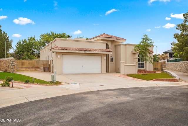 mediterranean / spanish house with driveway, stucco siding, and a tiled roof