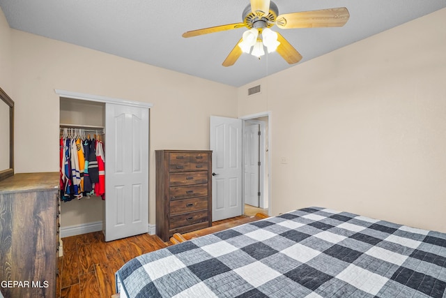 bedroom with a closet, wood finished floors, a ceiling fan, and baseboards