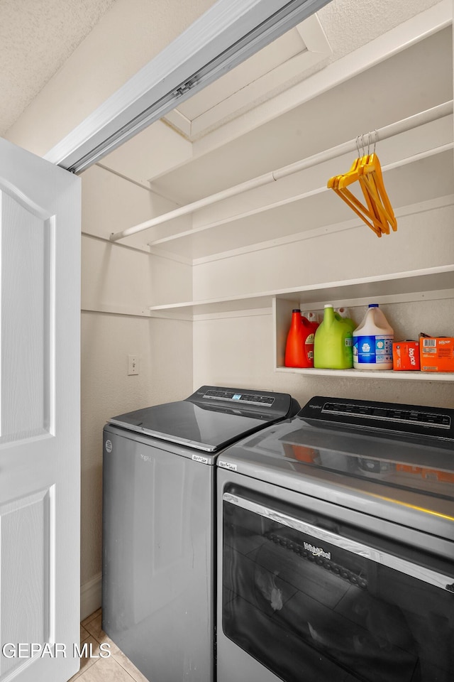 washroom with washer and dryer and tile patterned floors