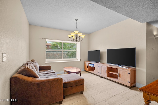 living room featuring a textured ceiling, a chandelier, and baseboards