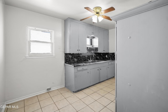3817 La Luz Ave, El Paso, TX 79903 - kitchen featuring a sink, ceiling fan, decorative backsplash, light tile patterned floors, and dark countertops