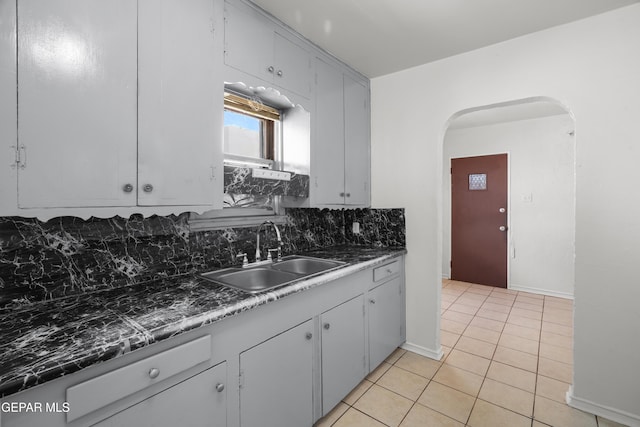 3817 La Luz Ave, El Paso, TX 79903 - kitchen with a sink, arched walkways, backsplash, light tile patterned flooring, and baseboards