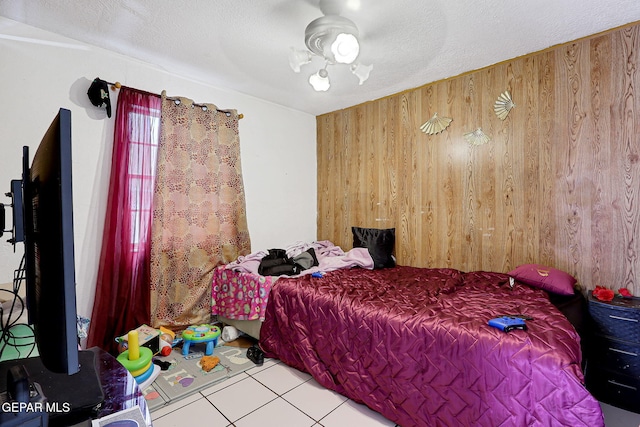 564 Chula Vista St, El Paso, TX 79915 - tiled bedroom featuring wooden walls and a textured ceiling