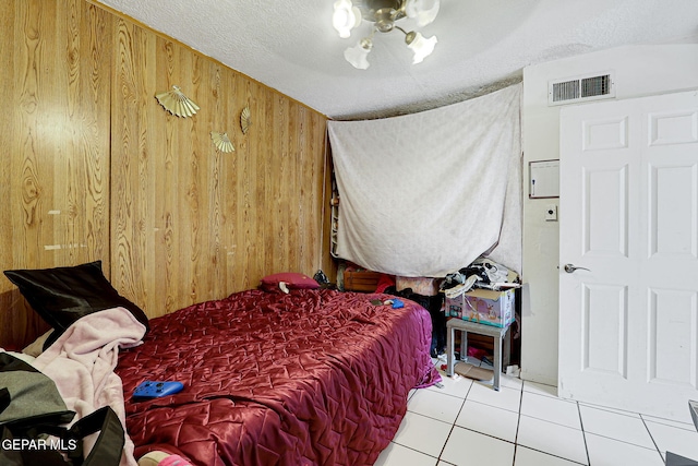 564 Chula Vista St, El Paso, TX 79915 - bedroom featuring wood walls, tile patterned flooring, and a textured ceiling