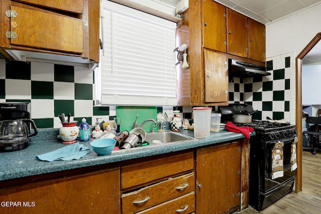 564 Chula Vista St, El Paso, TX 79915 - kitchen featuring black gas stove, backsplash, and brown cabinetry