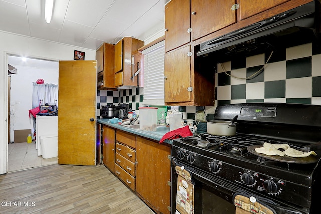 564 Chula Vista St, El Paso, TX 79915 - kitchen featuring black range with gas stovetop, brown cabinets, decorative backsplash, and light wood finished floors