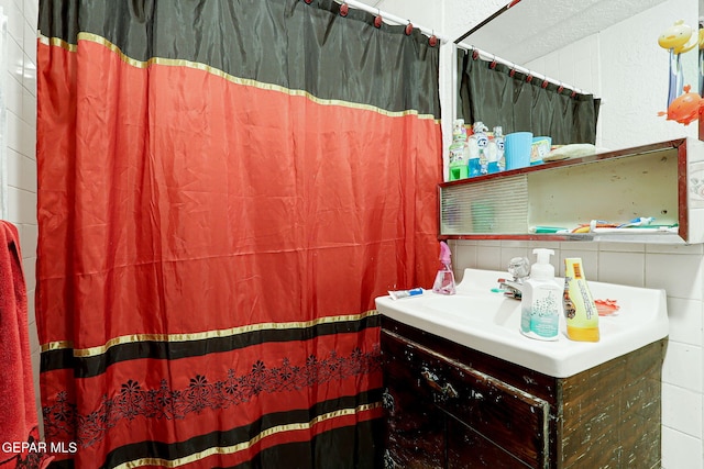 564 Chula Vista St, El Paso, TX 79915 - full bath with tile walls, vanity, and a shower with shower curtain