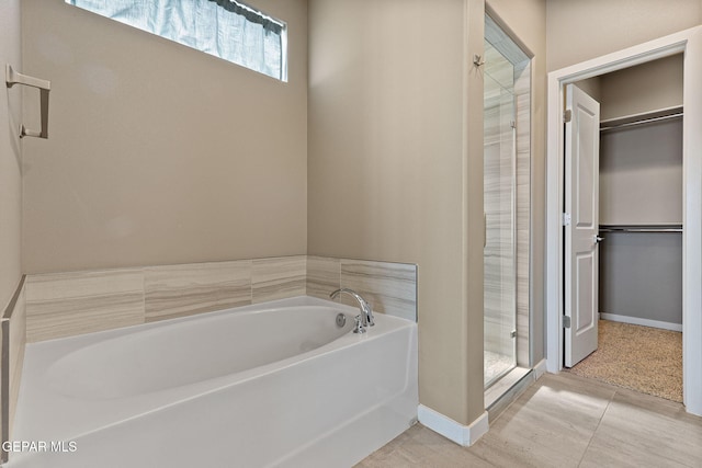 14172 Peyton Edwards Ave, El Paso, TX 79938 - full bathroom with a stall shower, a garden tub, a spacious closet, and baseboards
