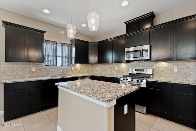 14172 Peyton Edwards Ave, El Paso, TX 79938 - kitchen with stainless steel appliances, a sink, a kitchen island, dark cabinetry, and recessed lighting