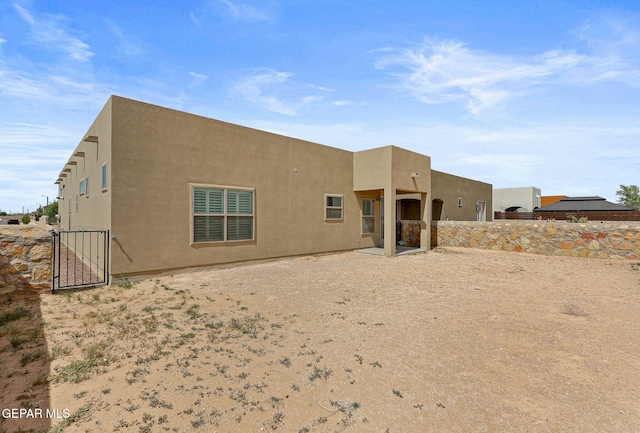 14172 Peyton Edwards Ave, El Paso, TX 79938 - rear view of house featuring stucco siding, fence, and a gate