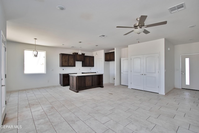 15341 Idea Ln, El Paso, TX 79938 - kitchen featuring dark brown cabinets, a ceiling fan, a kitchen island, light countertops, and baseboards