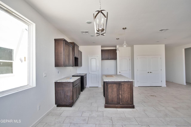15341 Idea Ln, El Paso, TX 79938 - kitchen featuring dark brown cabinets, a center island, a chandelier, and decorative light fixtures