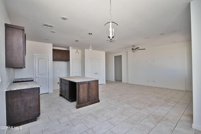 15341 Idea Ln, El Paso, TX 79938 - kitchen with dark brown cabinets, a ceiling fan, hanging light fixtures, open floor plan, and light stone countertops