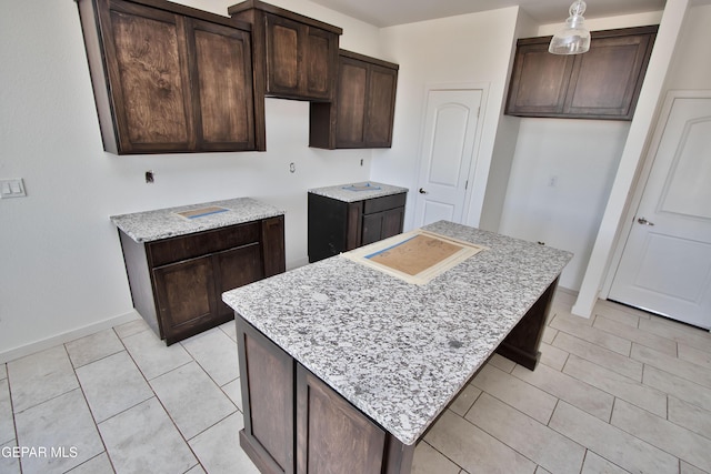 15341 Idea Ln, El Paso, TX 79938 - kitchen with dark brown cabinets, a center island, baseboards, and light tile patterned floors