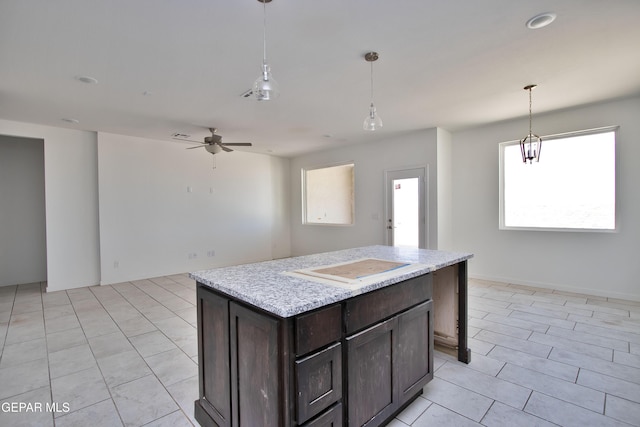 15341 Idea Ln, El Paso, TX 79938 - kitchen with light countertops, light tile patterned flooring, dark brown cabinets, a ceiling fan, and pendant lighting