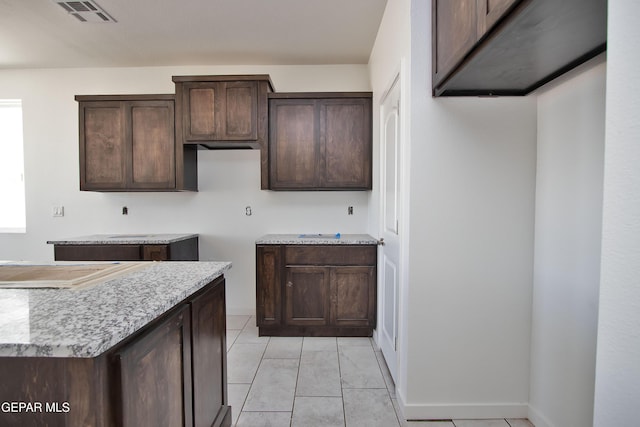 15341 Idea Ln, El Paso, TX 79938 - kitchen featuring dark brown cabinetry, light tile patterned flooring, and baseboards