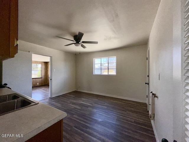 5017 Sierra Madre Dr, El Paso, TX 79904 - unfurnished living room with dark wood-style flooring, a ceiling fan, baseboards, and a sink