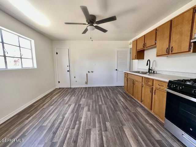 5017 Sierra Madre Dr, El Paso, TX 79904 - kitchen with range with gas cooktop, a sink, brown cabinets, a ceiling fan, and light countertops