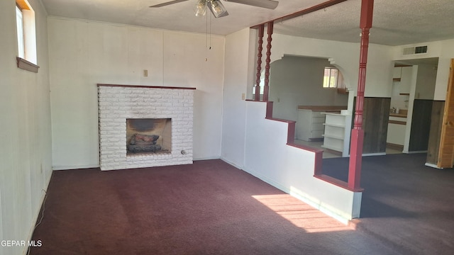 223 Kelvin Ave, El Paso, TX 79915 - unfurnished living room featuring ceiling fan, a brick fireplace, carpet floors, plenty of natural light, and a textured ceiling