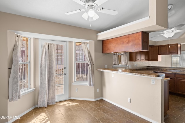 10740 White Sands Dr, El Paso, TX 79924 - kitchen with ceiling fan, plenty of natural light, decorative backsplash, and a peninsula