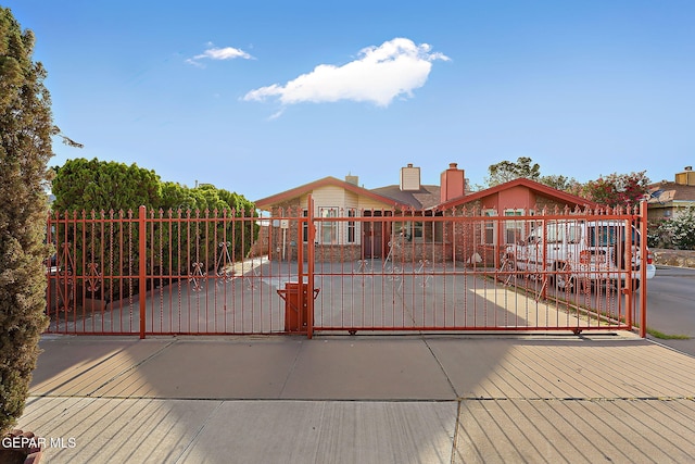 819 Los Surcos Rd, El Paso, TX 79907 - view of front of home with a gate, a fenced front yard, and a chimney