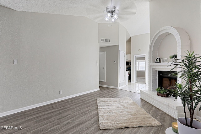 819 Los Surcos Rd, El Paso, TX 79907 - living room featuring ceiling fan, baseboards, a brick fireplace, wood finished floors, and high vaulted ceiling
