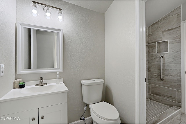 819 Los Surcos Rd, El Paso, TX 79907 - bathroom featuring toilet, tiled shower, vanity, and baseboards