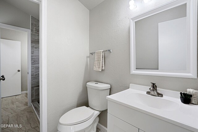 819 Los Surcos Rd, El Paso, TX 79907 - bathroom featuring marble look tiles, toilet, vanity, and a shower stall