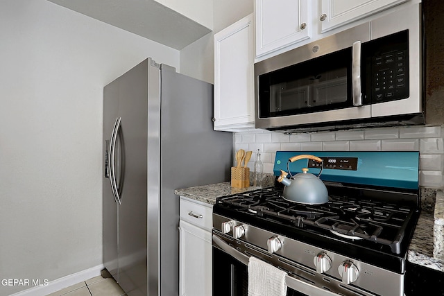 819 Los Surcos Rd, El Paso, TX 79907 - kitchen featuring appliances with stainless steel finishes, backsplash, light stone counters, white cabinets, and light tile patterned floors