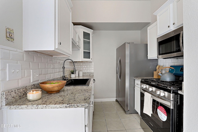 819 Los Surcos Rd, El Paso, TX 79907 - kitchen with stainless steel appliances, a sink, backsplash, and white cabinetry