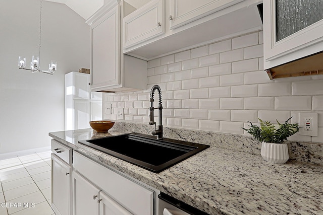 819 Los Surcos Rd, El Paso, TX 79907 - kitchen with a sink, a chandelier, light tile patterned floors, white cabinetry, and backsplash