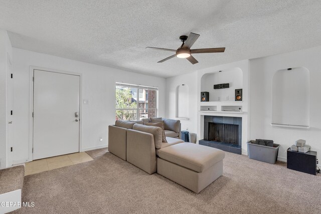 4433 Stanton St Unit T37, El Paso, TX 79902 - tiled living room featuring carpet flooring, a ceiling fan, a textured ceiling, and a tiled fireplace