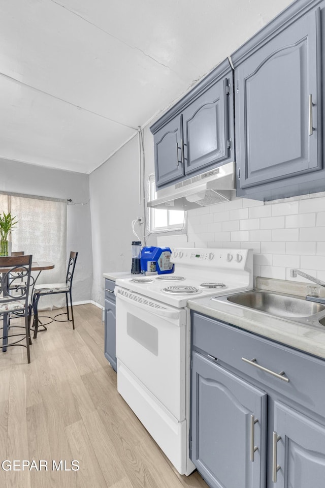 720 Johnson St, Fabens, TX 79838 - kitchen with under cabinet range hood, electric range, light wood-type flooring, and light countertops